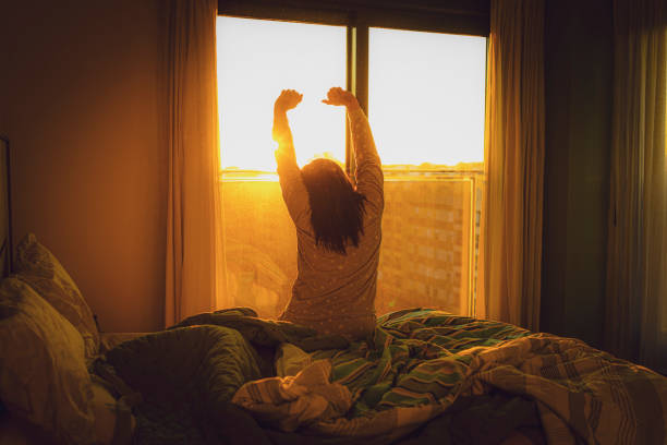 Woman stretching in front of a window in warm morning light
