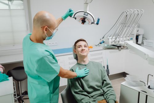 Dentist examining a smiling patient in a modern clinic
