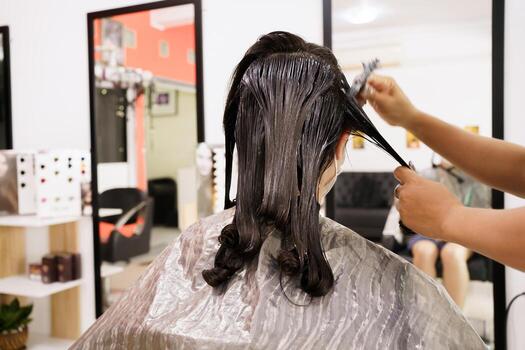 Hair stylist applying a hair treatment in a salon